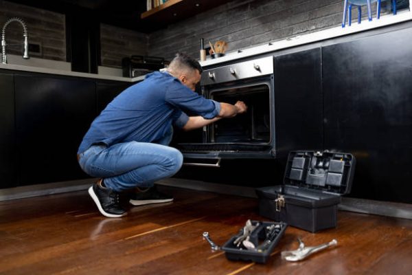 Kitchen Appliance Services repair Latin American electrician installing an oven at a house - home improvement concepts