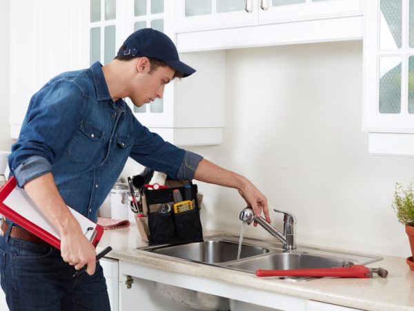 Plumber. Professional plumber doing reparation in kitchen home.